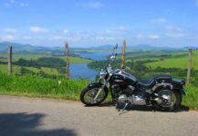 Uma moto e ao fundo a cidade Joanópolis a Capital do Lobisomem