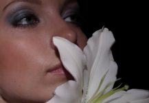 mulher sentido o aroma de uma flor