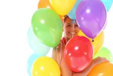 uma pessoa segurando várias bexigas coloridas