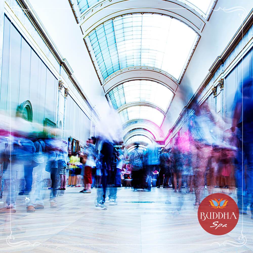 A foto mostra um museu com exposição de quadros, mas como se as pessoas estivessem em um ritmo super acelerado e só é possível ver borrões das pessoas. Isso para mostrar Efeitos Negativos da modernização da sociedade