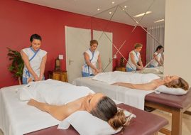 Moça recebendo massagem nos pés. Ela está deitada de barriga para cima em uma cama - Mini Day Spa Buddha Spa