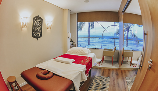 Quarto da unidade Buddha Spa São Luís. Uma cama muito bem arrumada e um armário com espelho grande